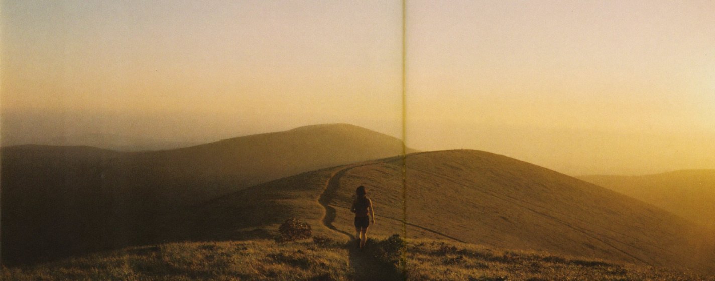 Runner on a ridgeline trail at golden hour