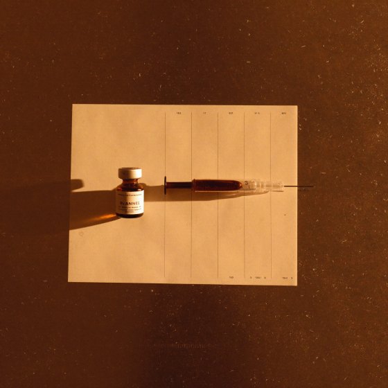 Sermorelin vial and syringe on a paper log